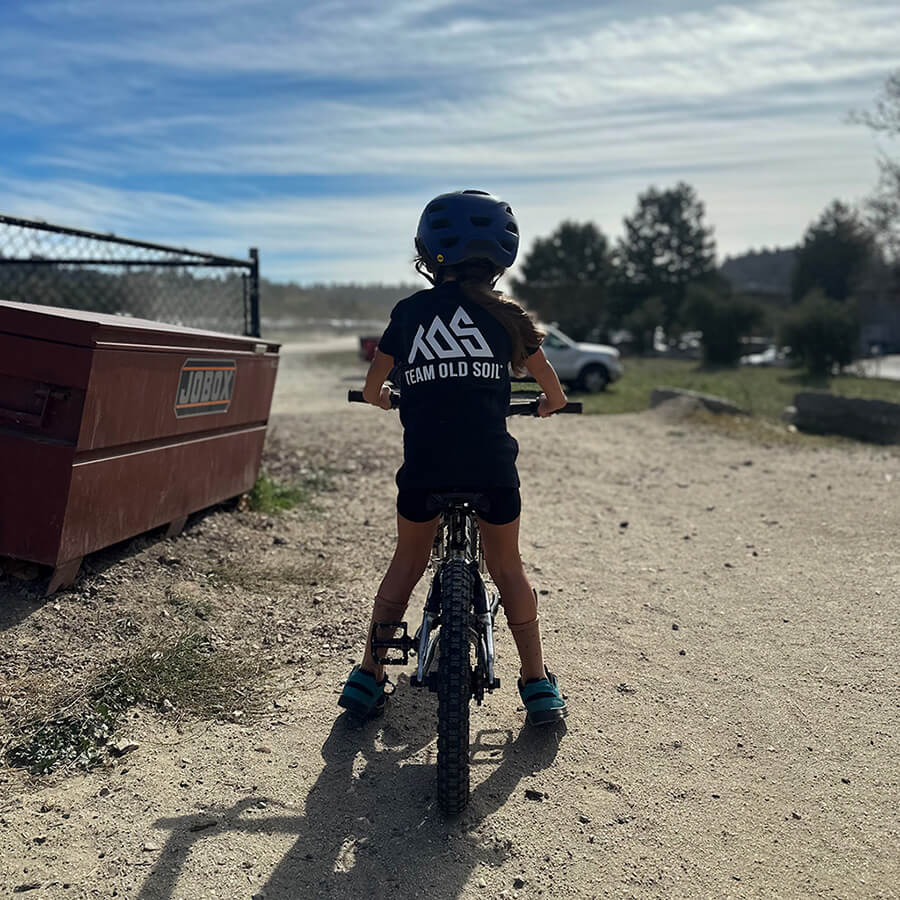 Detailed image of the back TOS logo in black. Youth Premium Classic shirt.